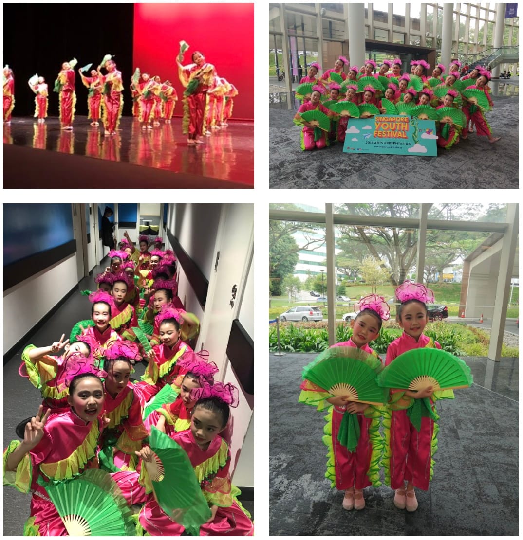 Girls in pink and green Chinese dance costumes hold large green fans at the Singapore Youth Festival 2018.
